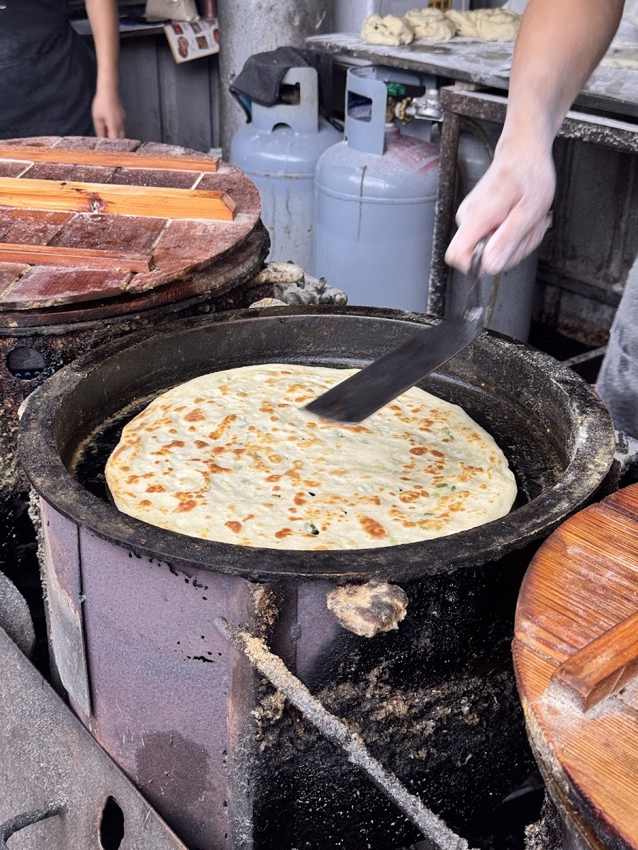 蔥油餅在炭爐鐵鍋上煎至金黃宜蘭