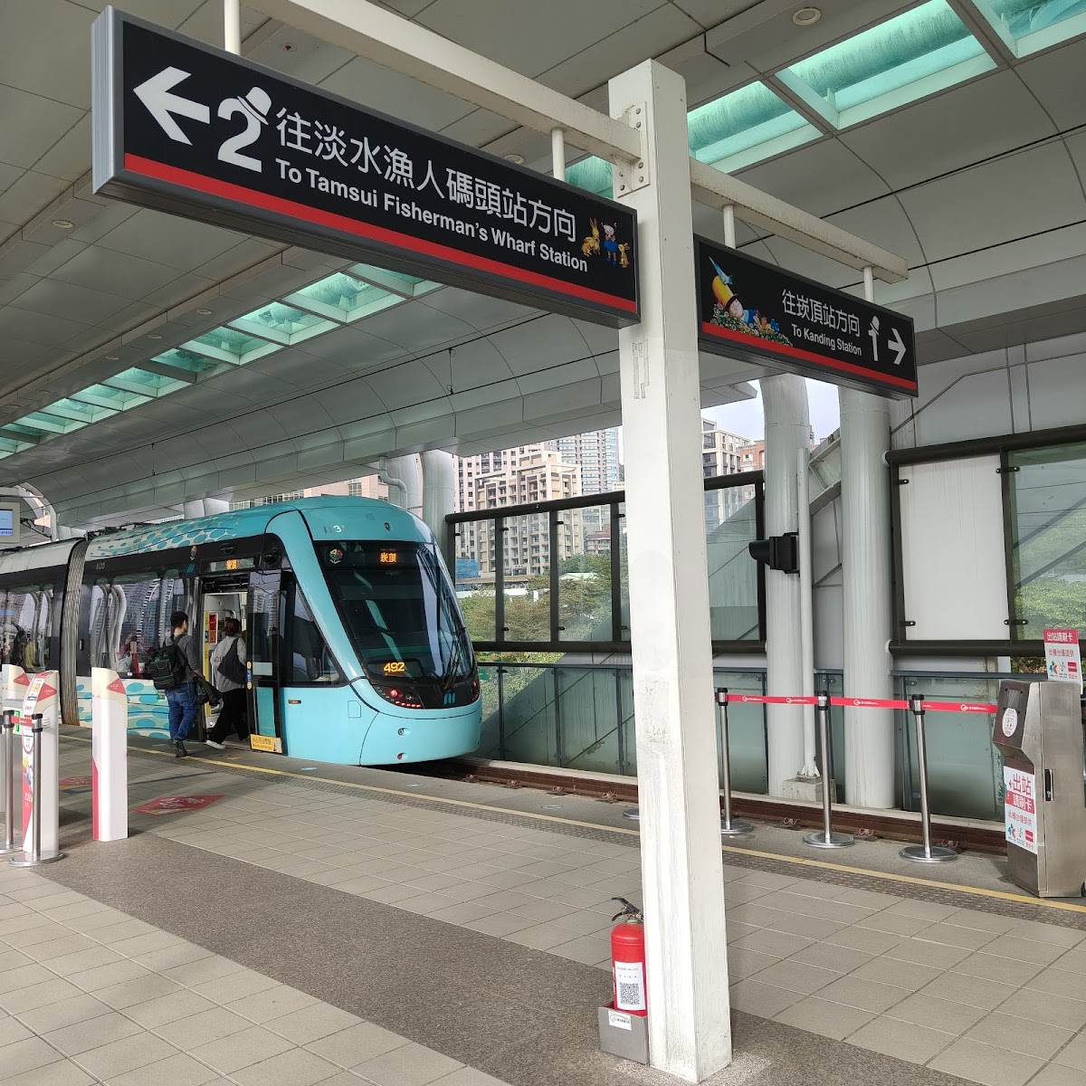 淡水輕軌站內往漁人碼頭方向指示牌,藍綠色電車停靠站台