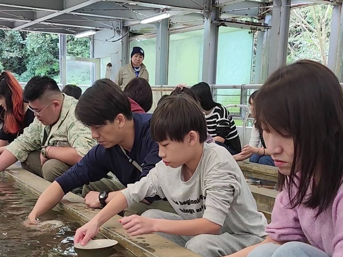 黃金博物館淘金體驗，遊客在水槽旁篩選砂金