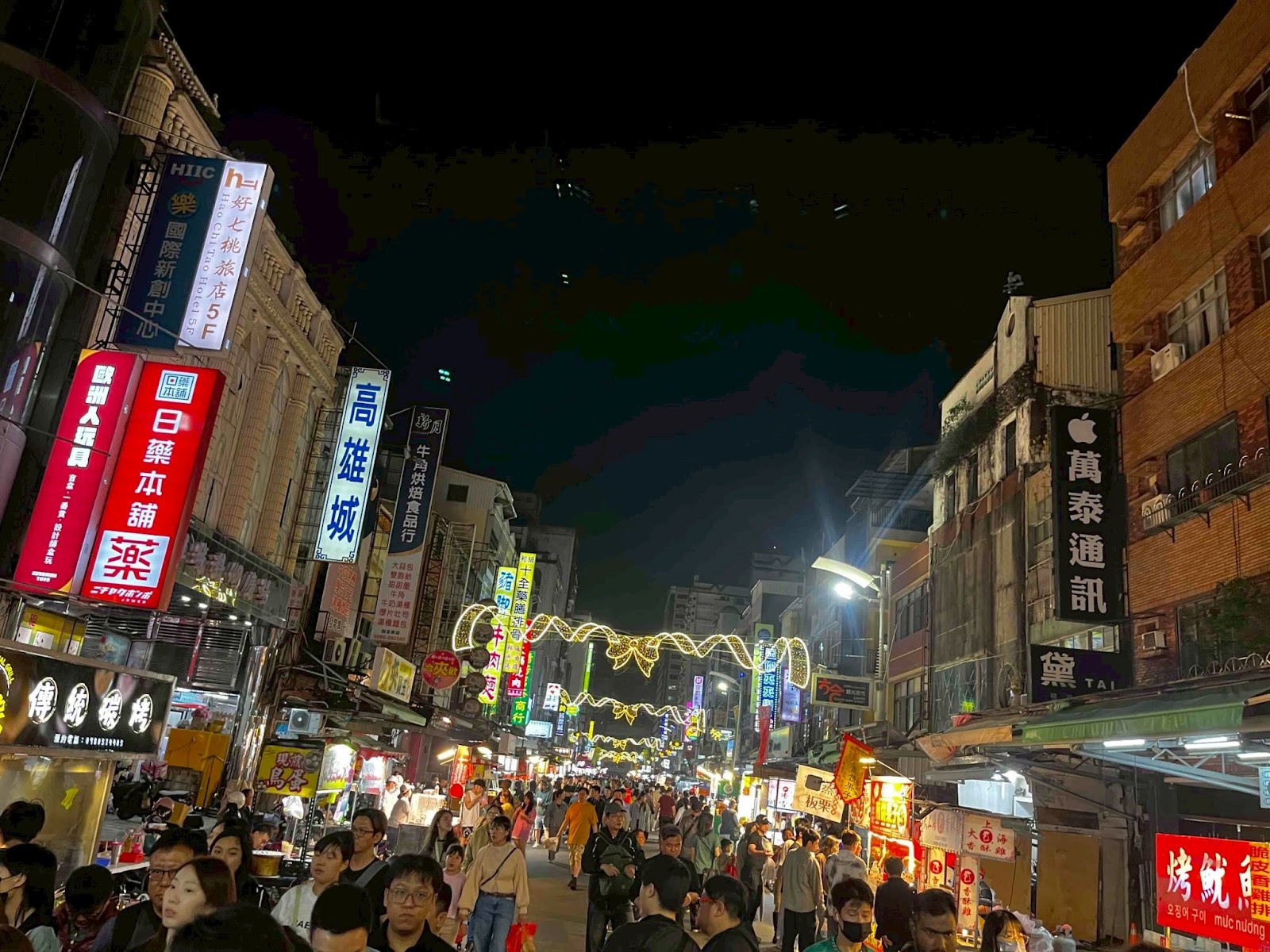 高雄六合夜市街道南端夜景,各色霓虹招牌林立,人潮熙攘