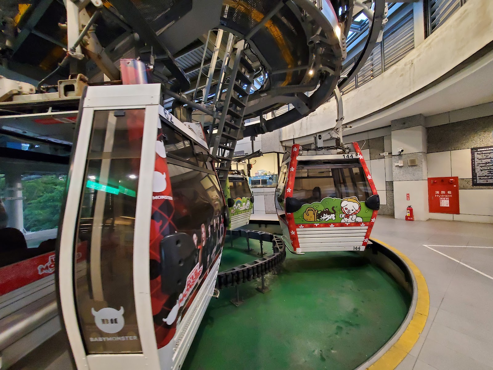 貓空纜車彩繪車廂進站，色彩繽紛，旅客排隊準備搭乘