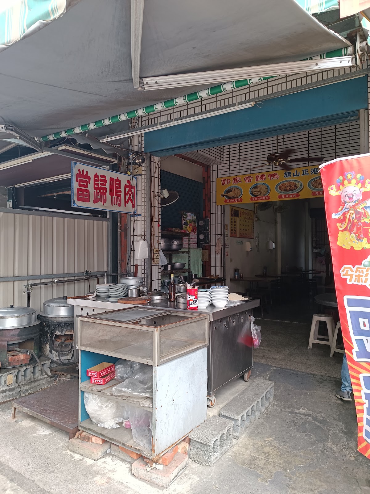 當歸鴨攤位不鏽鋼爐台與大型鑄鐵鍋，爐火慢燉香氣四溢