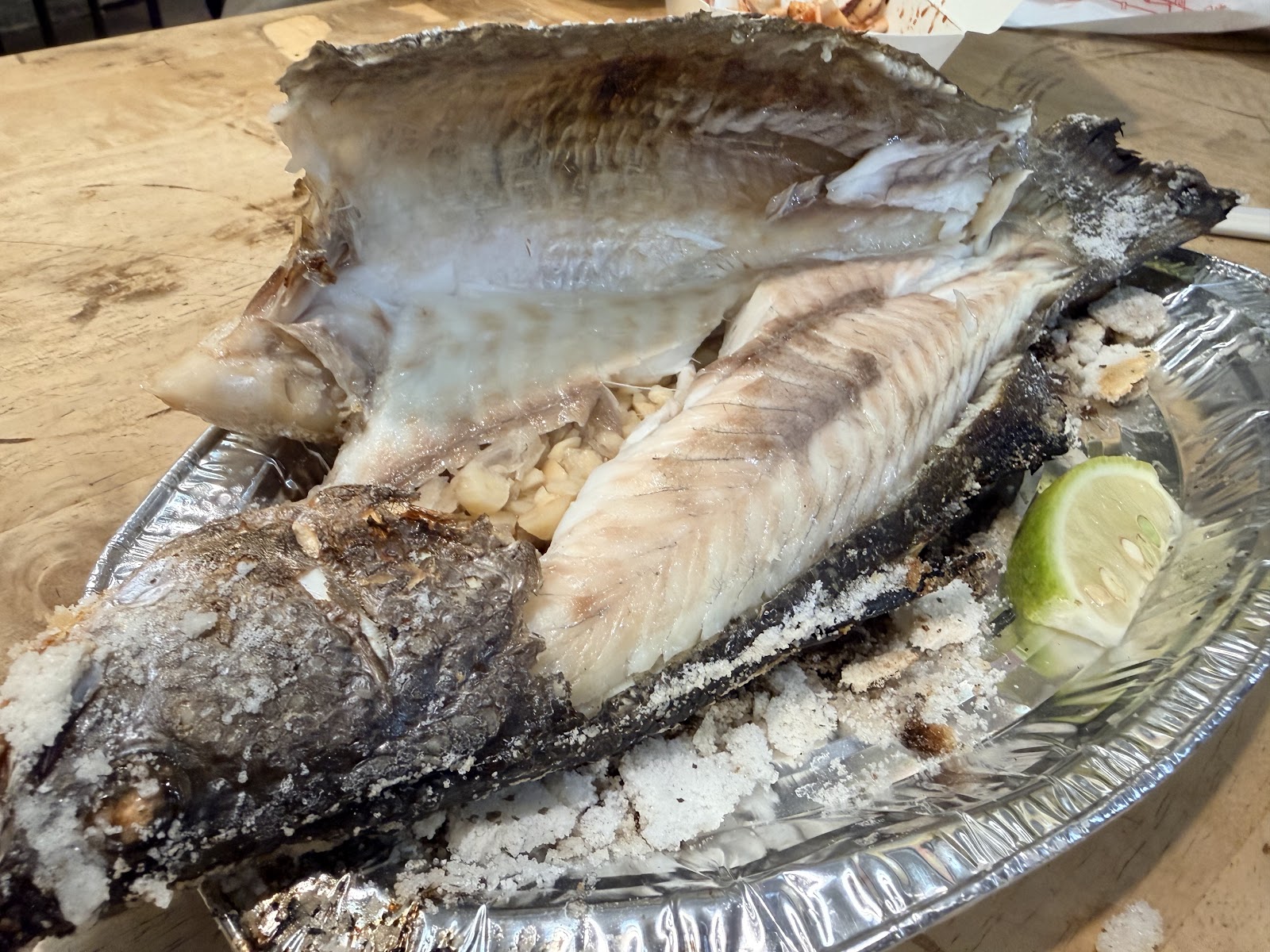 逢甲夜市鹽烤虱目魚整條剖開，撒滿粗鹽，錫箔盤盛裝，附上新鮮檸檬
