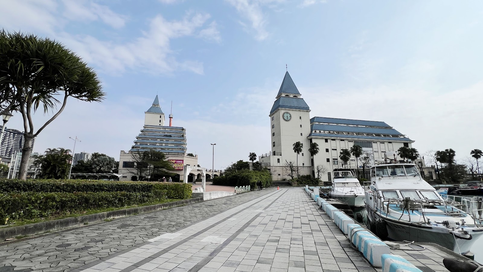 漁人碼頭步道,右側停靠遊艇,前方是尖塔式歐式城堡建築,晴天藍天