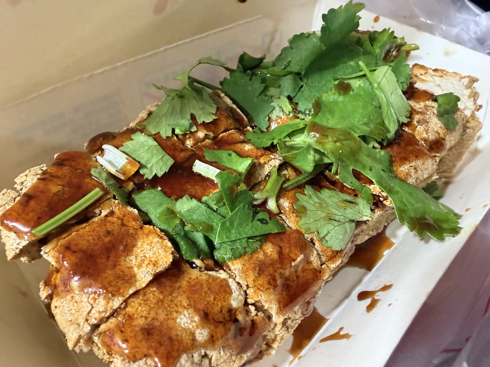 逢甲夜市炸臭豆腐金黃酥脆，淋甜辣醬鋪滿香菜，台灣夜市經典小吃