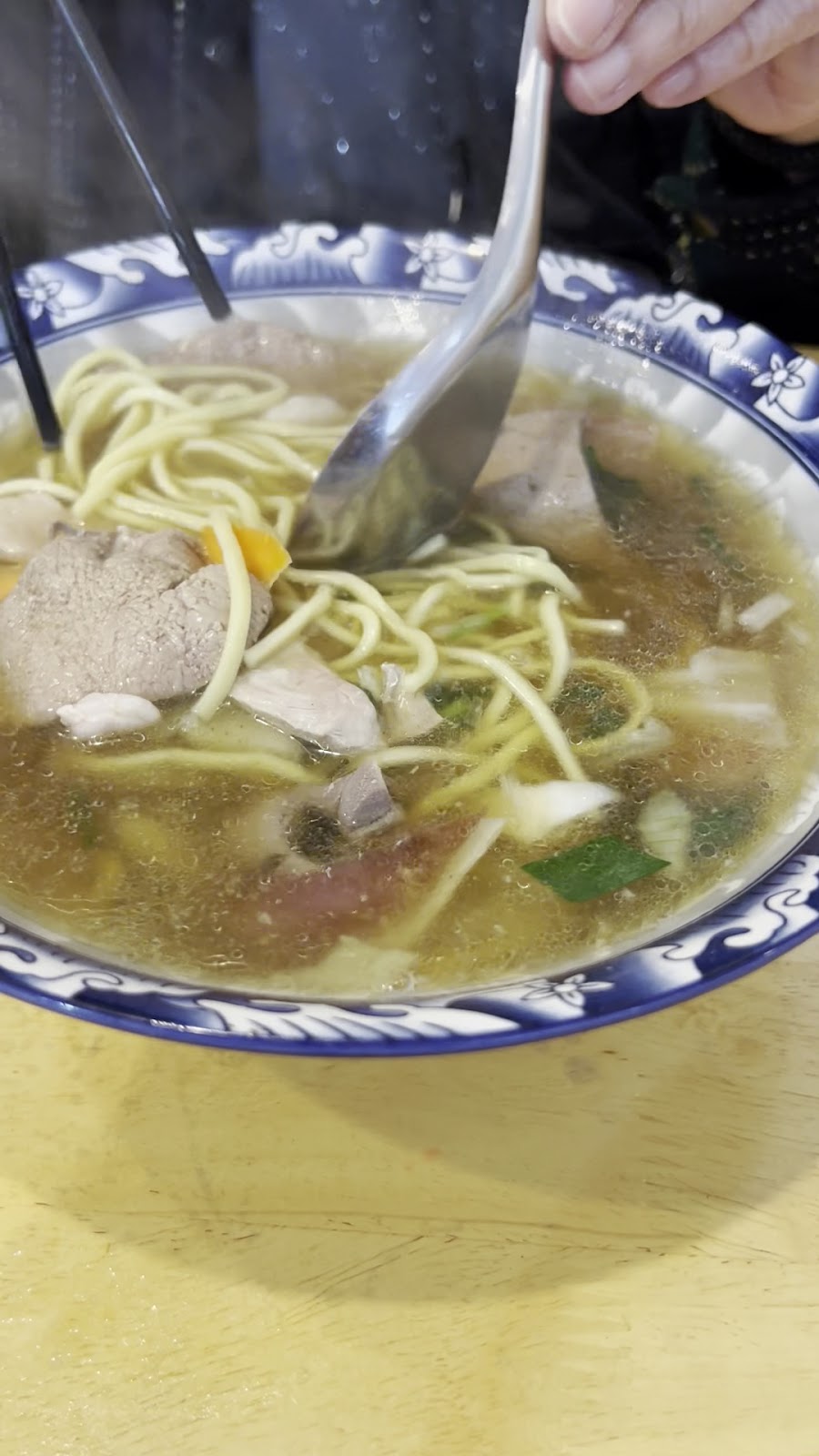 阿聰師什錦湯麵筷子夾麵特寫，可見Q彈麵條