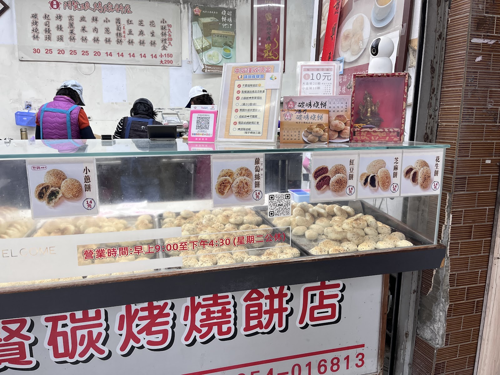 五結阿賢碳烤燒餅店招牌及展示台，顯示週二公休與營業時間