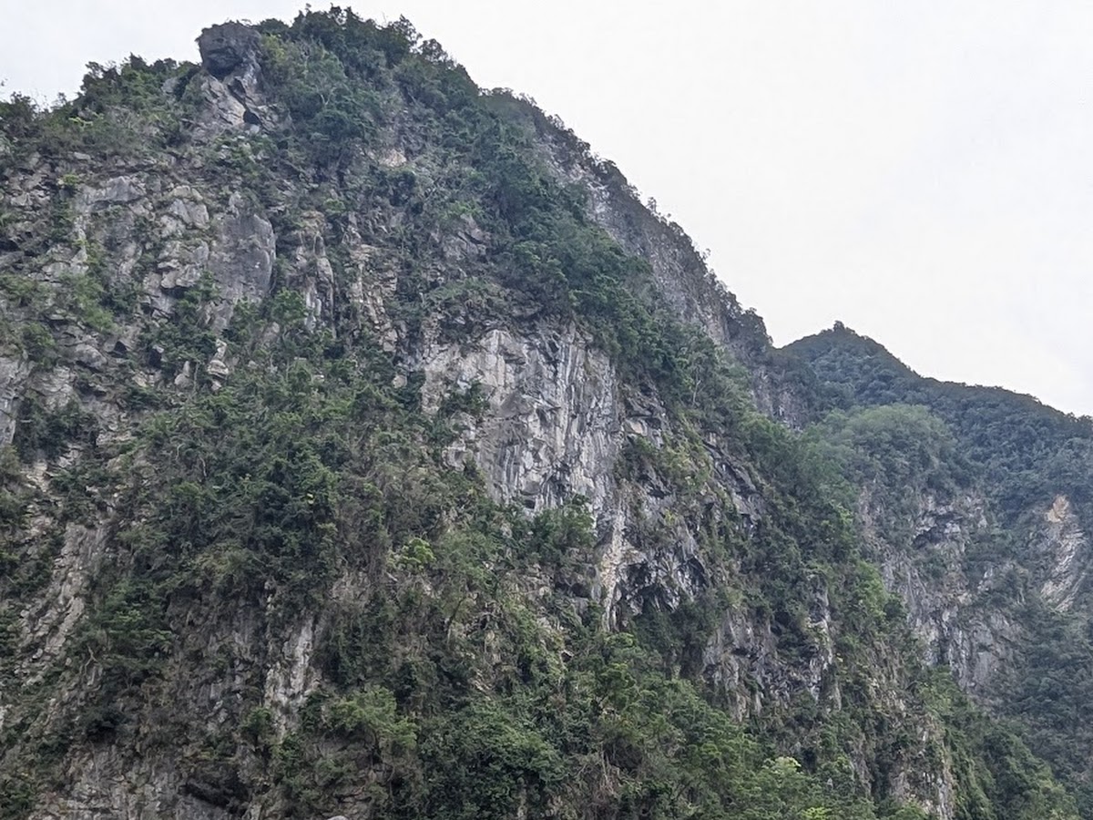 太魯閣公路隧道入口，兩側石獅子守衛，高聳大理石峭壁背景