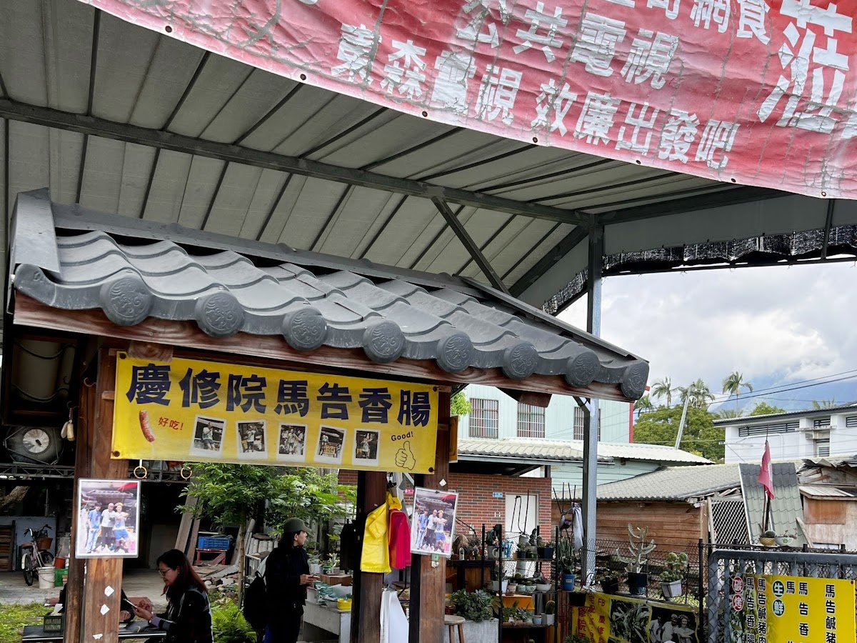 慶修院馬告香腸攤位外觀，黃色招牌和宅配看板