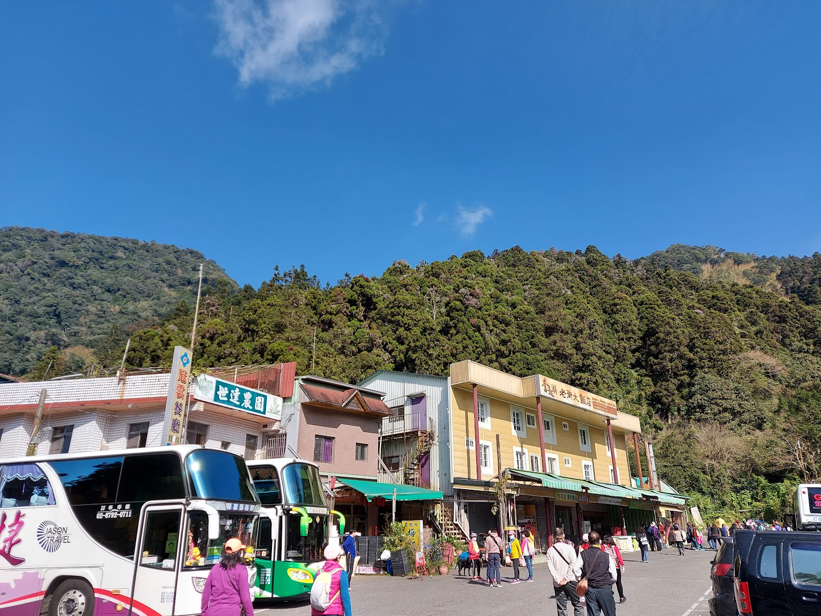 奮起湖老街彩色建築街景，遊覽車停靠，山景遠景