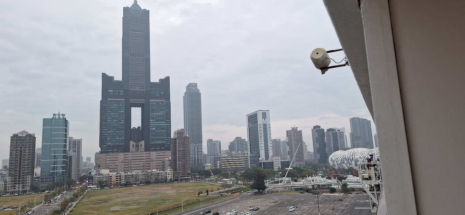 從高架視角俯瞰85大樓與高雄港，雲層低沉氣勢磅礡