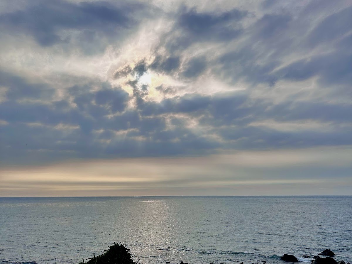 台灣最北點海岸夕陽，光芒穿透雲層照耀台灣海峽，北海岸日落美景