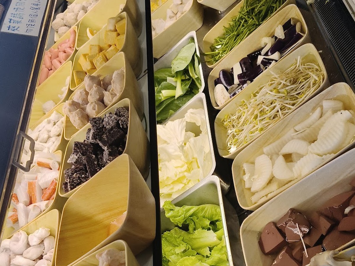 誠石火鍋岡山店自助蔬菜吧近拍，金針菇高麗菜豆腐黑木耳分格整齊排列