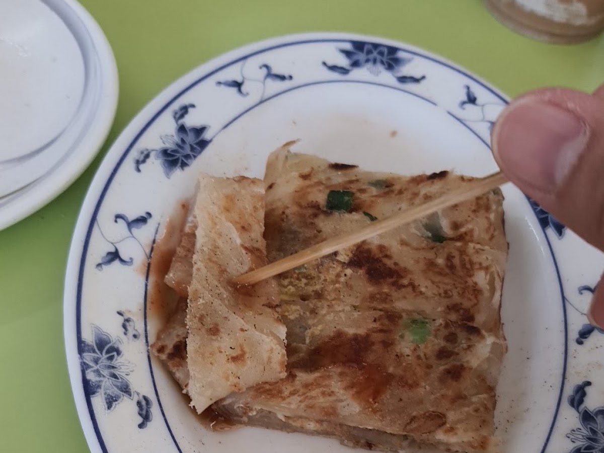 梓官美而美早餐店蛋餅盛在白色瓷盤上，外皮金黃酥脆