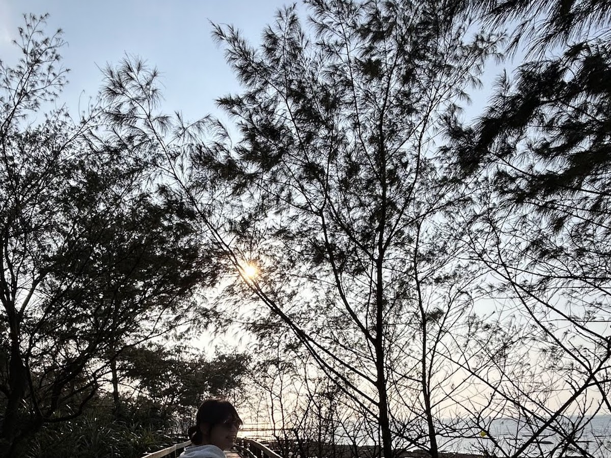 遊客漫步麟山鼻木棧道夕陽剪影，北海岸浪漫景色，石門旅遊景點