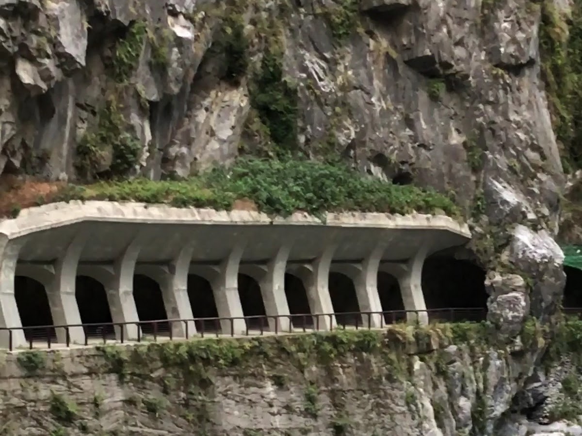 太魯閣峽谷懸崖步道拱廊，白色拱橋嵌入大理石峭壁，立霧溪河床可見