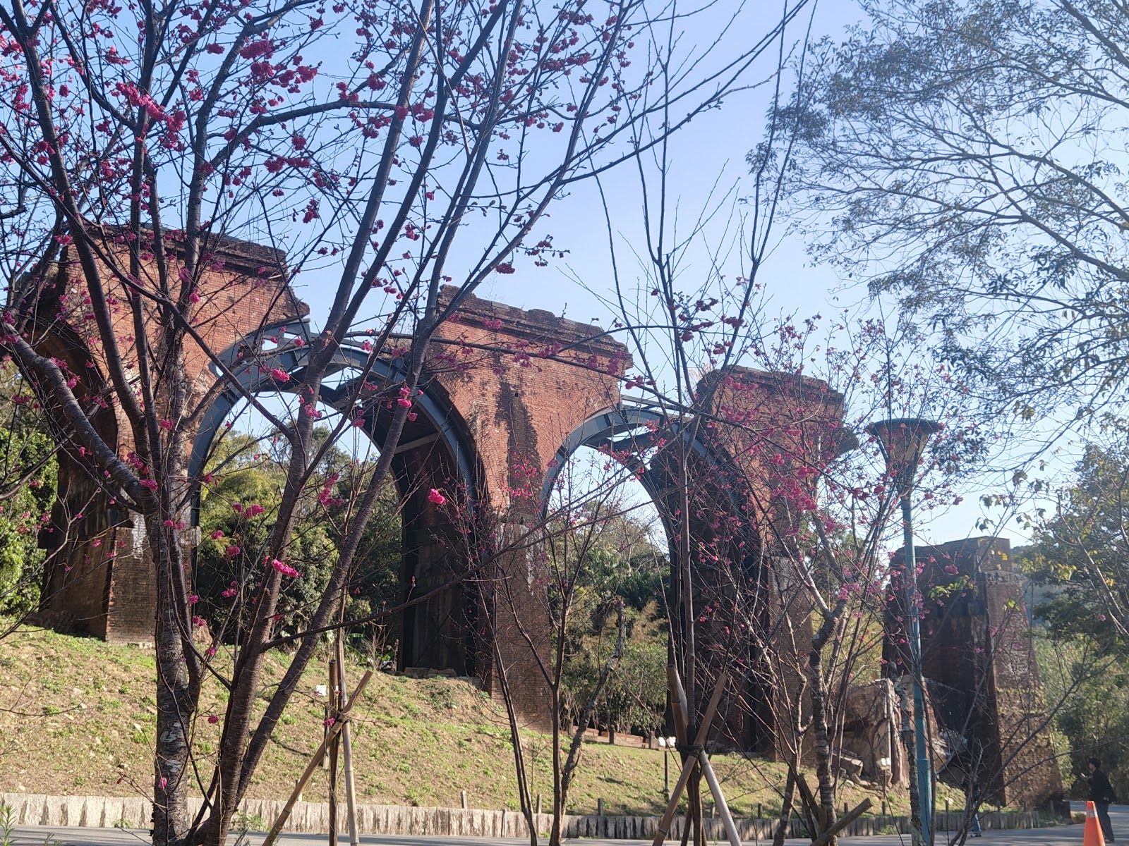 龍騰斷橋紅磚橋墩仰拍藍天綠樹背景