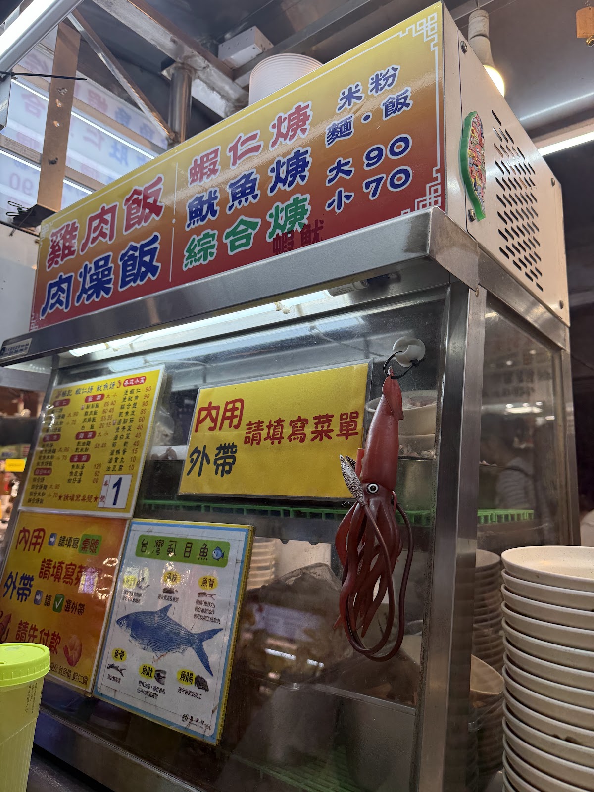 夜市海鮮燒烤攤位,菜單顯示雞肉飯、魷魚燒、蝦仁燒