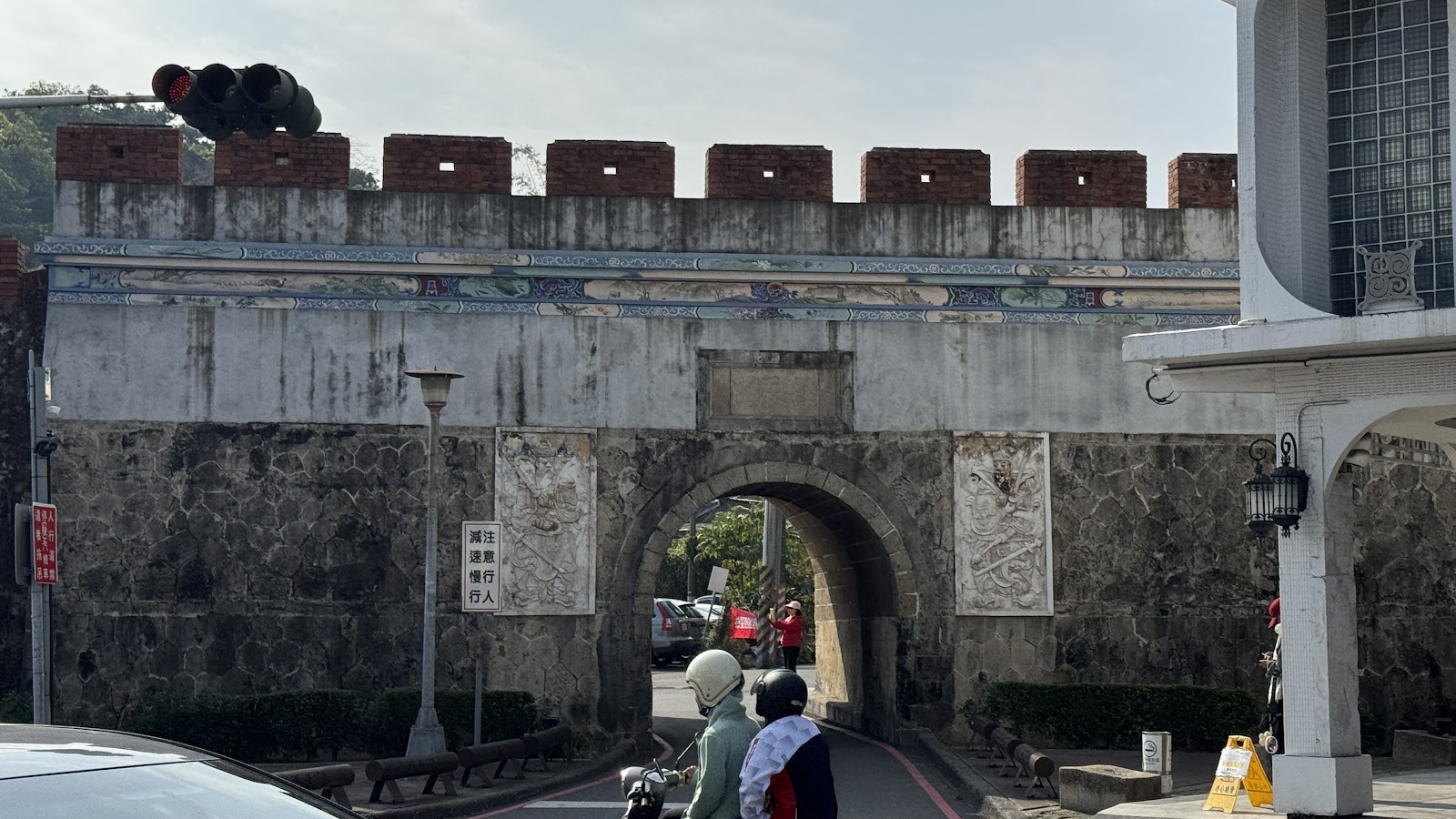 高雄左營舊城北門拱辰門另一角度,周圍有機車與行人經過,古蹟融入日常生活