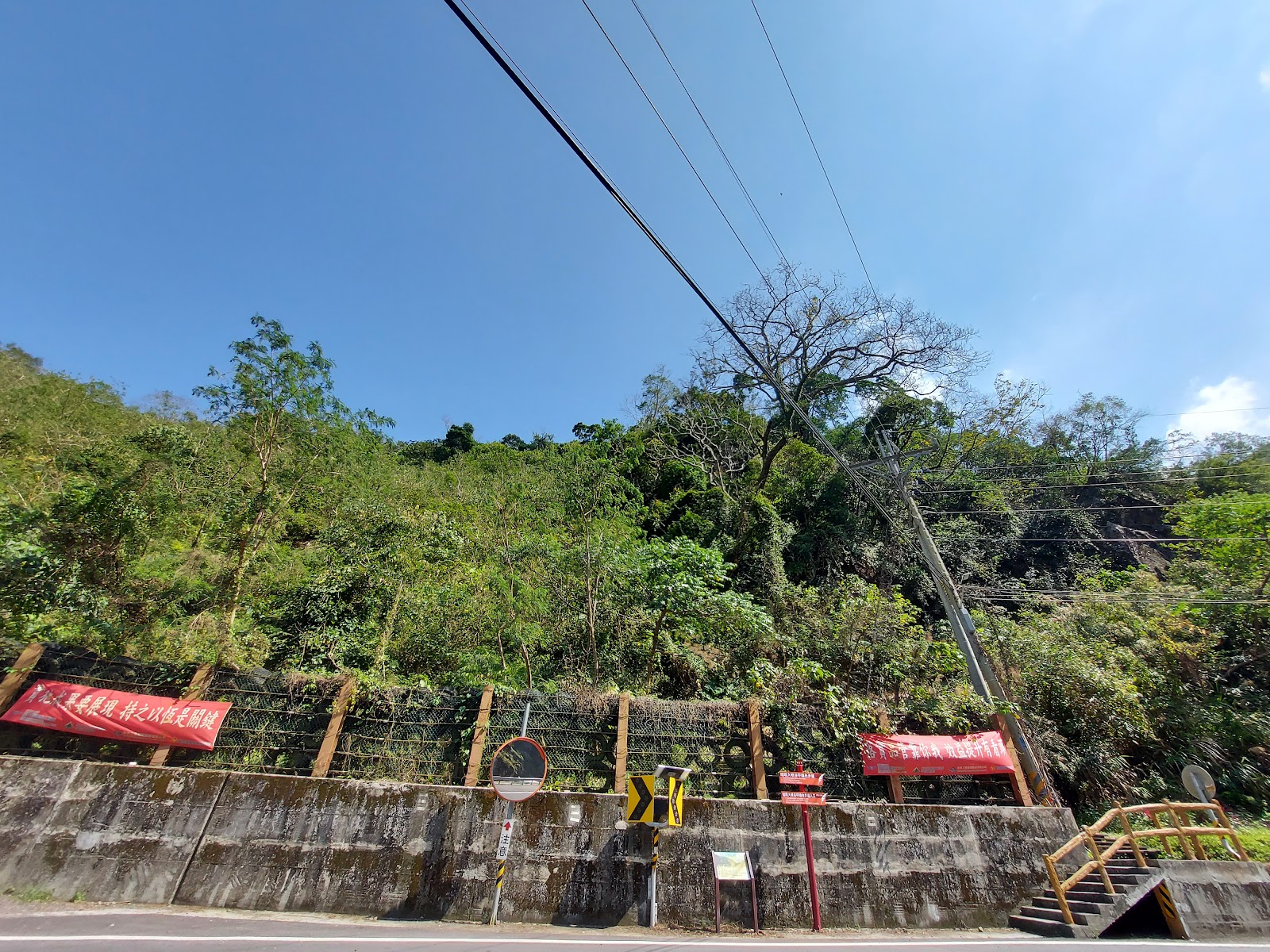 嗡嗡大峽谷入口，茂密山坡綠樹紅色橫幅和階梯入口