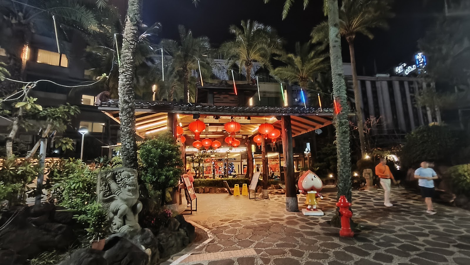 礁溪溫泉區夜晚日式餐廳外觀，紅燈籠高掛，棕櫚樹圍繞，夜間燈光溫暖迷人