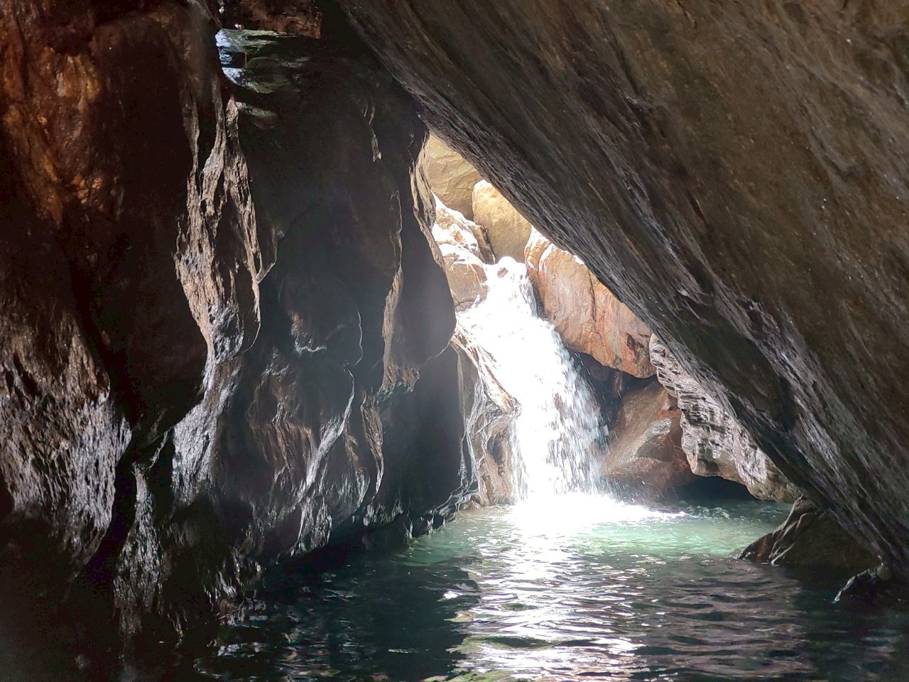 金岳瀑布岩洞內部,瀑布從岩縫傾瀉,碧綠潭水,宜蘭南澳祕境