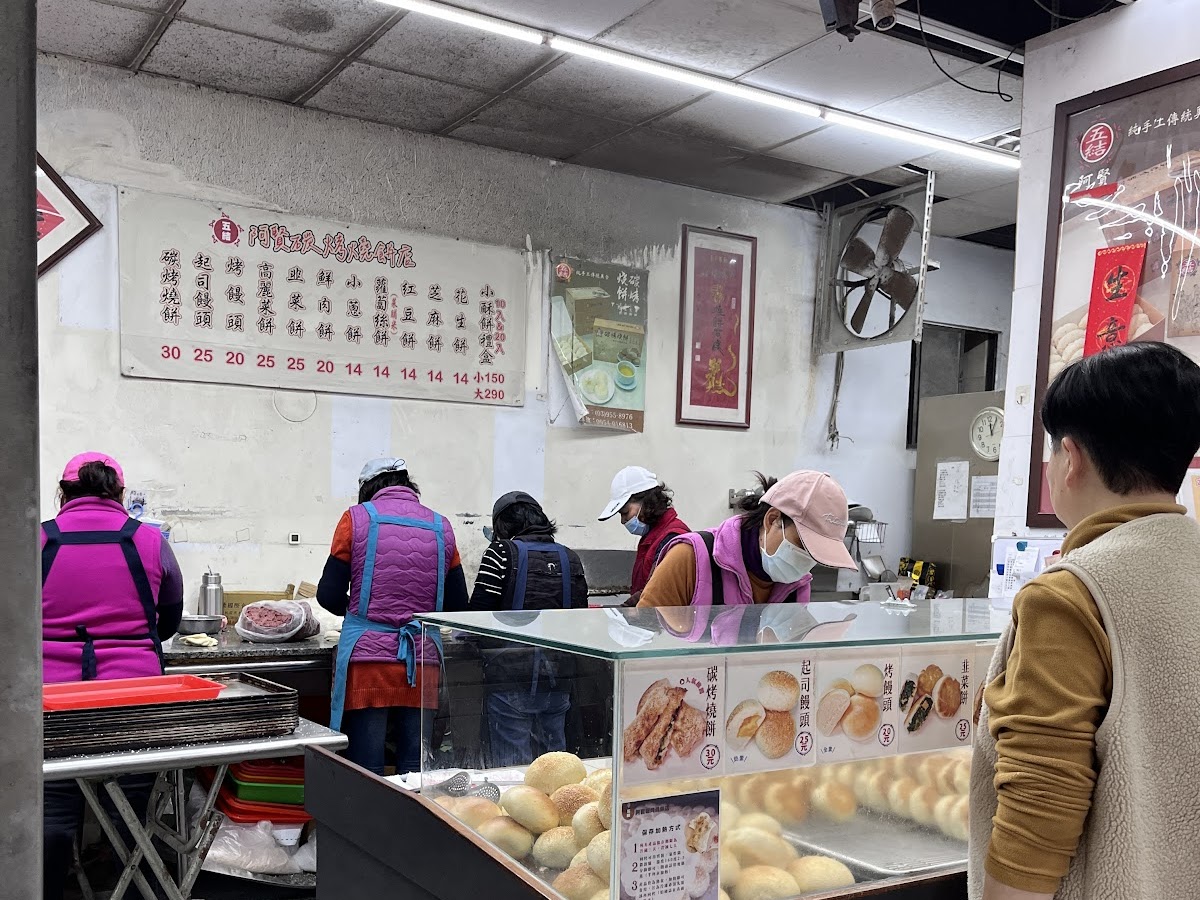 五結阿賢碳烤燒餅店店內顧客排隊點餐，員工分工製作