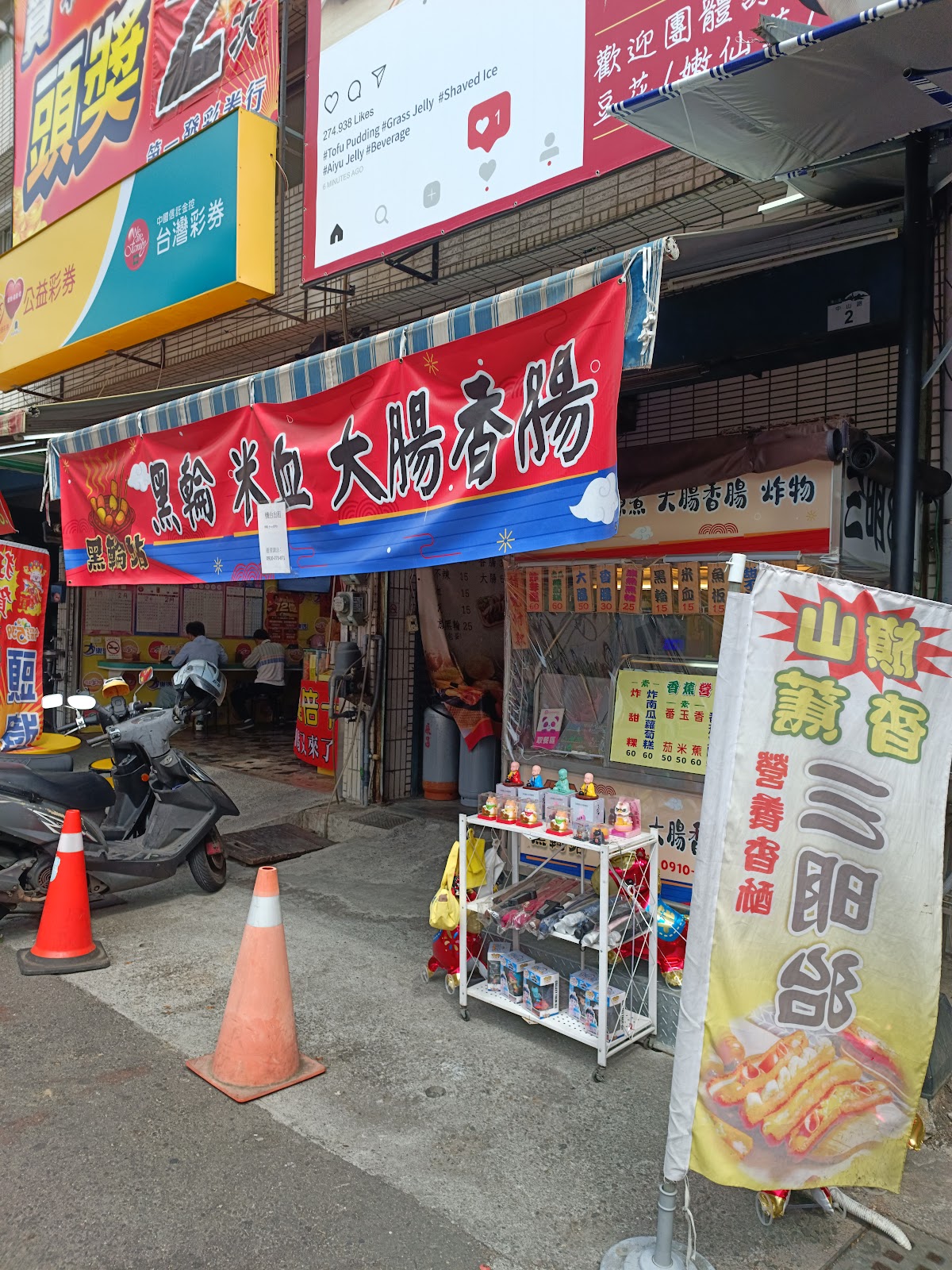 旗山老街黑輪米血大腸香腸攤，紅色大橫幅，攤前食客聚集