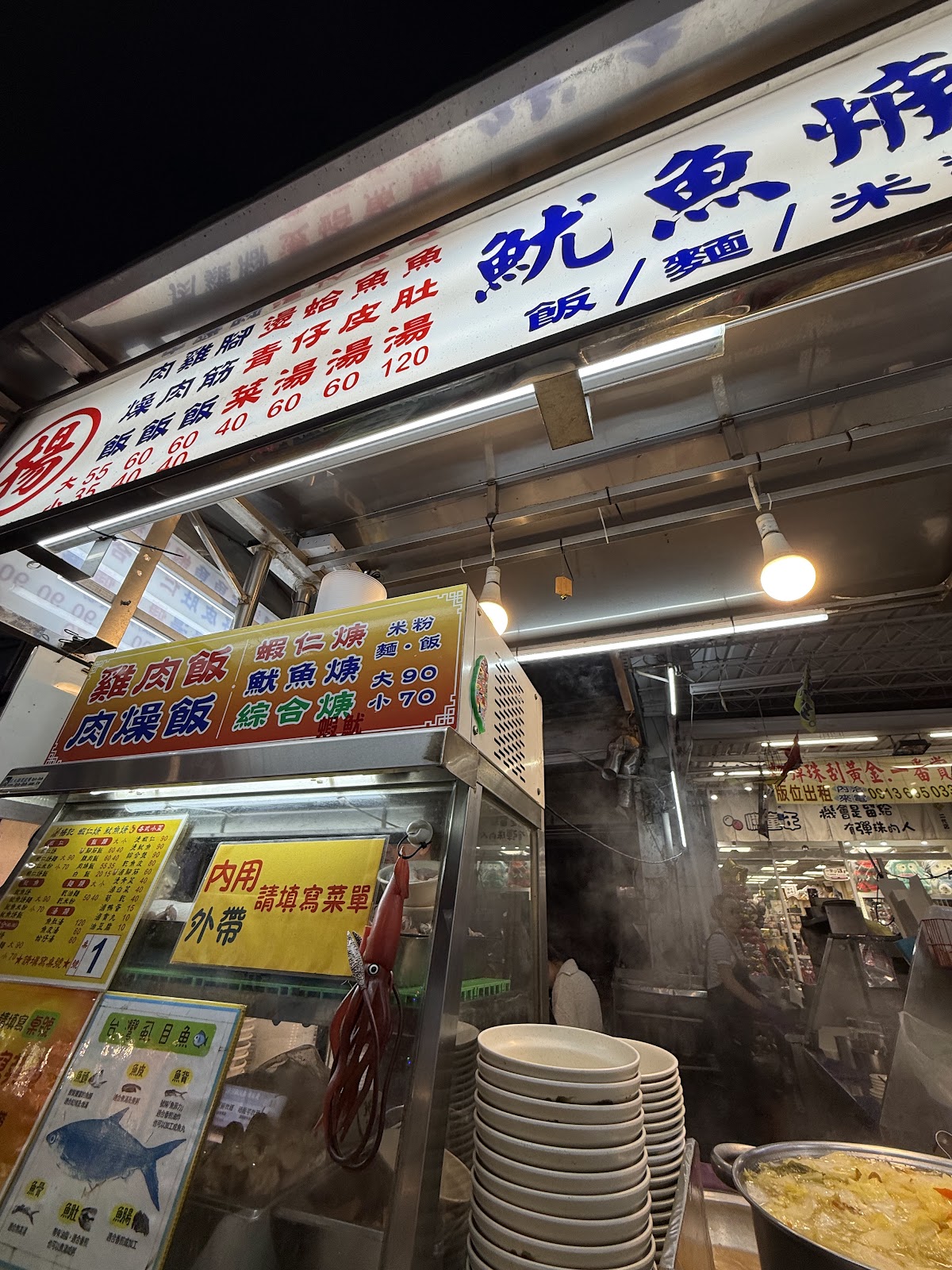 六合夜市魷魚焿攤夜景,熱氣瀰漫,菜牌清晰可見