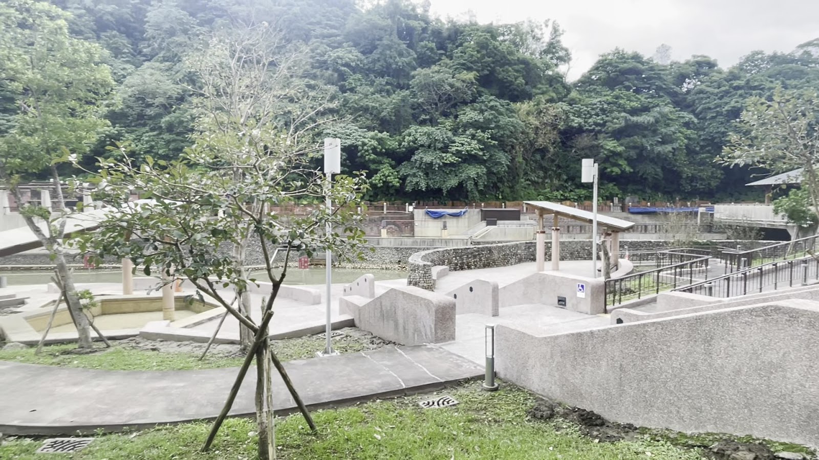蘇澳冷泉公園戶外露天區，石板步道與大眾冷泉池，背景青山