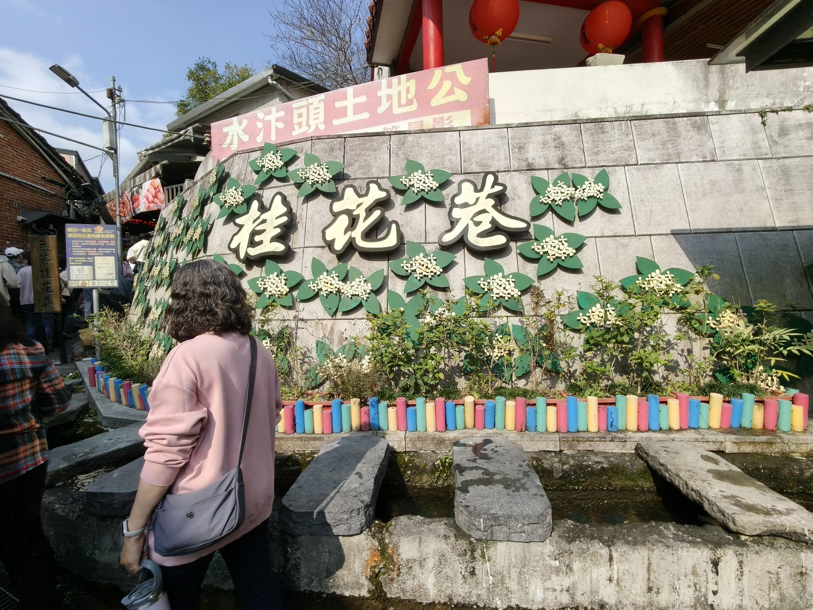 桂花巷立體招牌，綠葉白花，紅燈籠，遊客觀賞