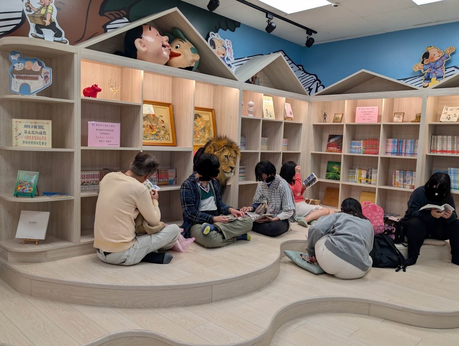 劉興欽漫畫博物館館內閱讀區，漫畫壁畫天花板，木質書架，孩子席地閱讀