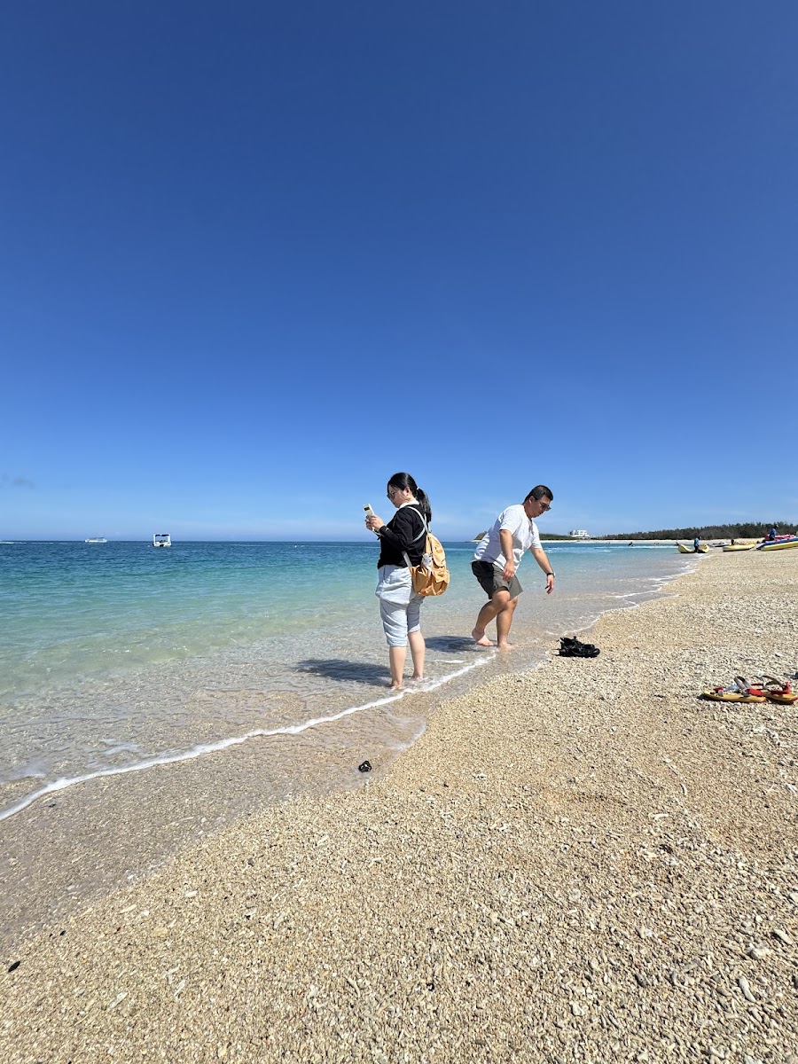 澎湖吉貝島遊客在淺灘戲水,碧藍天空背景