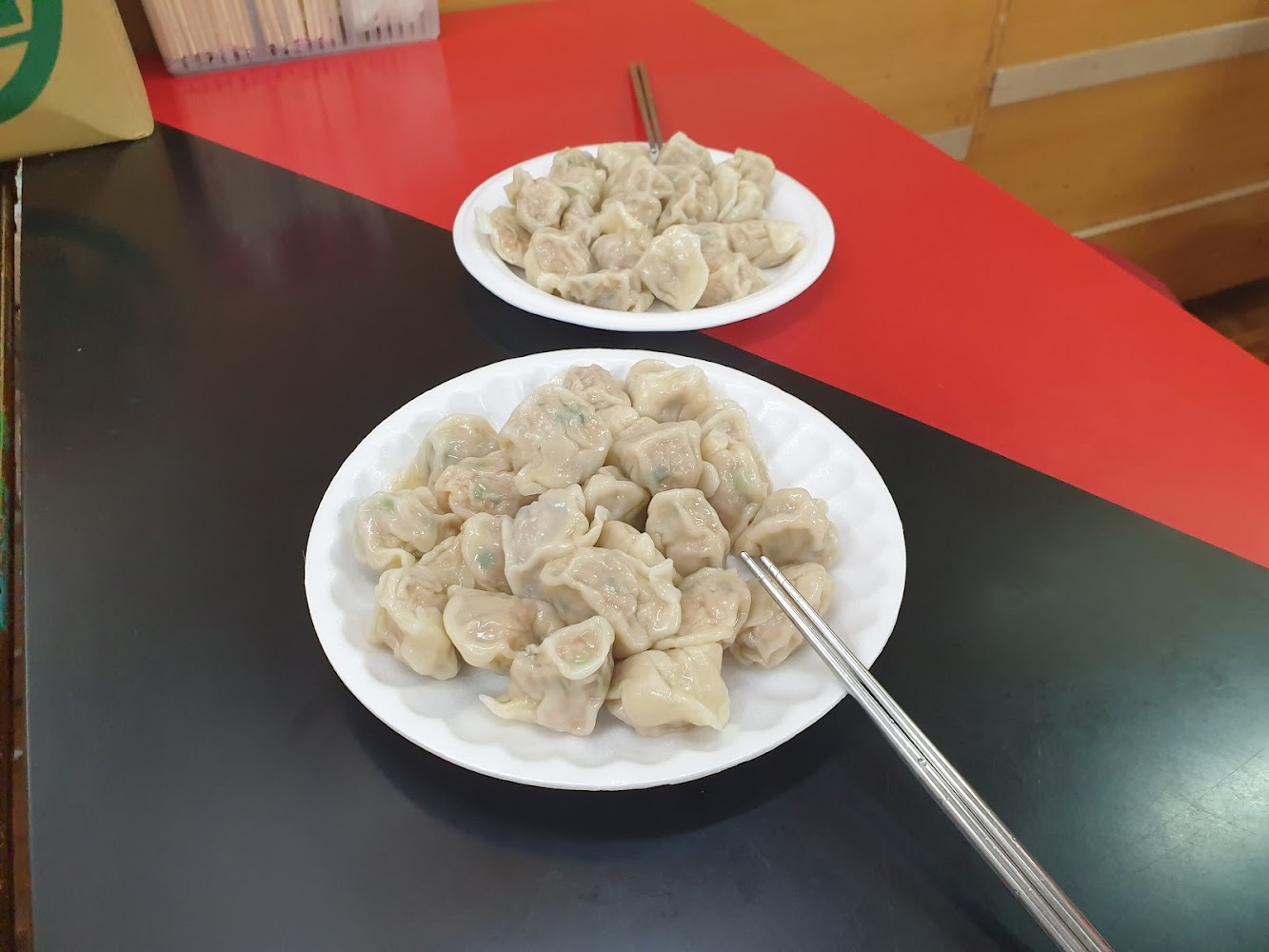 兩盤水餃放在白色圓盤裡