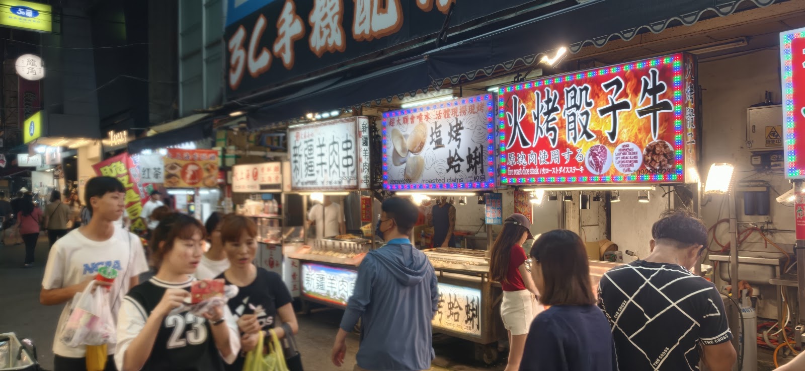 逢甲夜市攤販人潮夜晚，霓虹招牌燈火通明人聲鼎沸