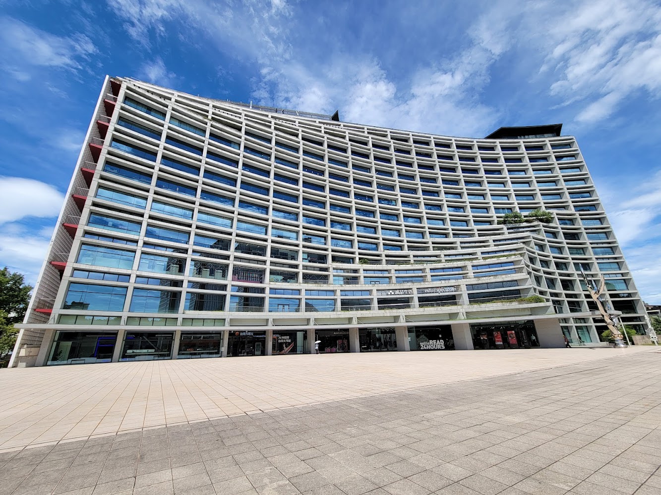 誠品生活松菸外觀，現代感曲線玻璃建築與開闊廣場