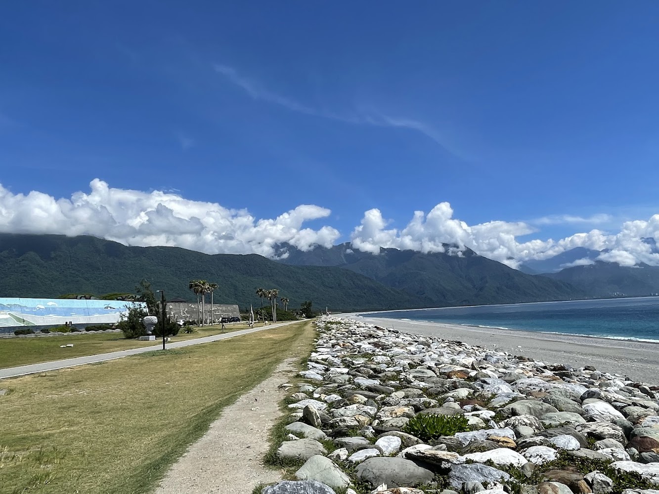 左側草地人行步道與右側海岸石堤並列的七星潭景色