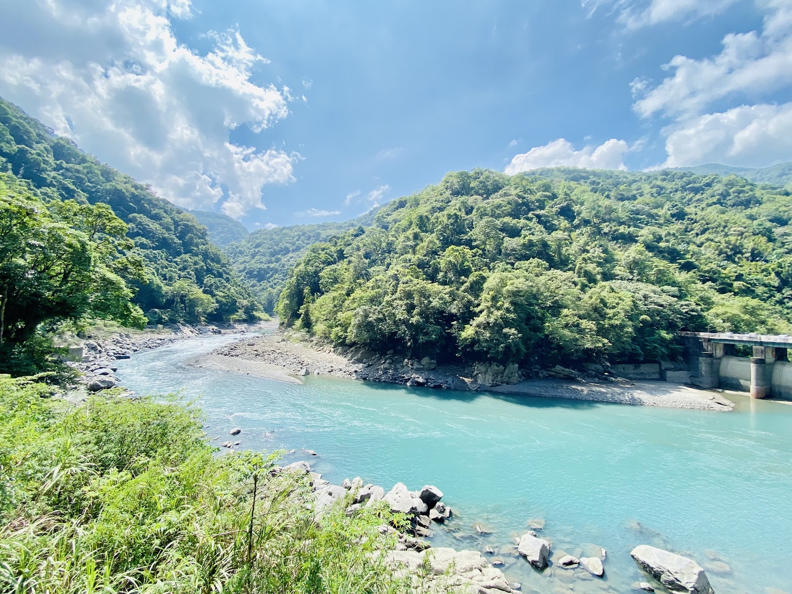 南勢溪翡翠藍綠色溪流，兩岸翠綠山林，藍天白雲