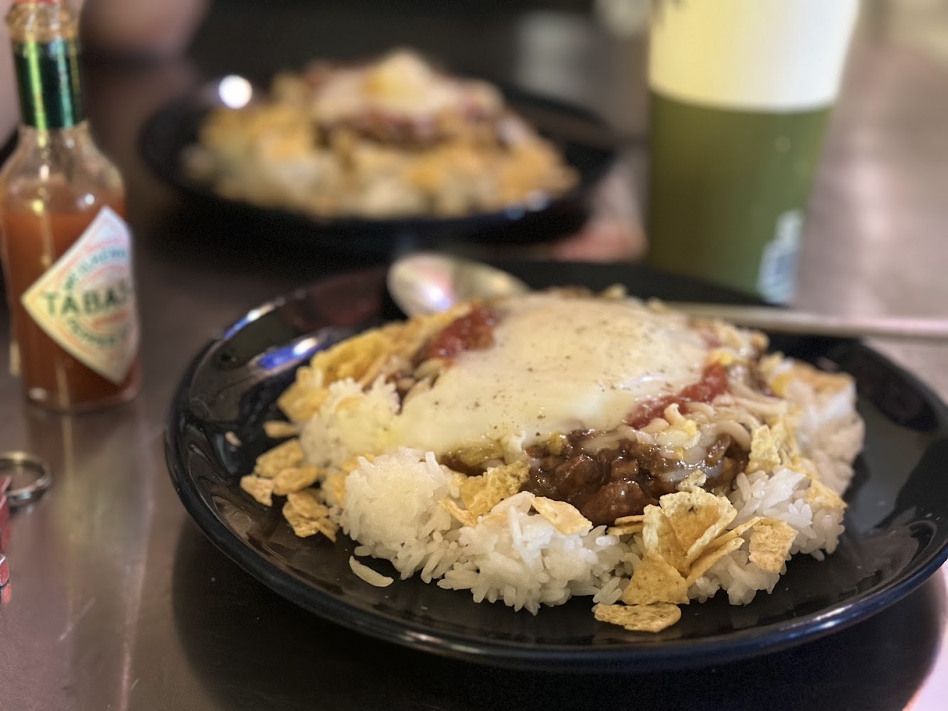 午夜市場塔可飯上鋪著起司牛肉醬與玉米脆片，旁邊放著Tabasco辣醬
