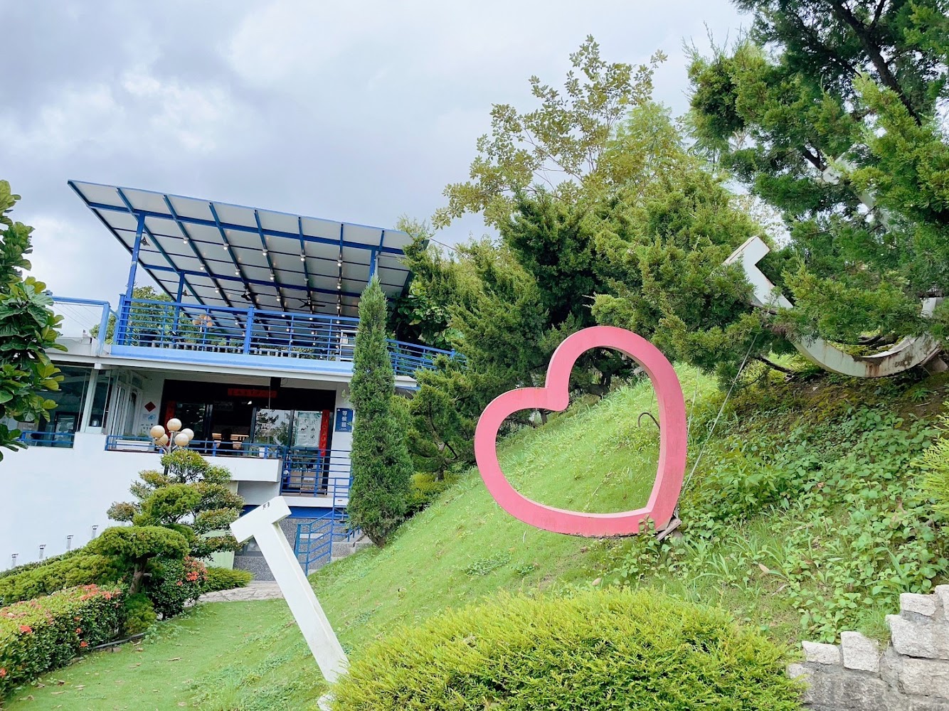 沃野山丘餐廳藍白建築與草地愛心裝置