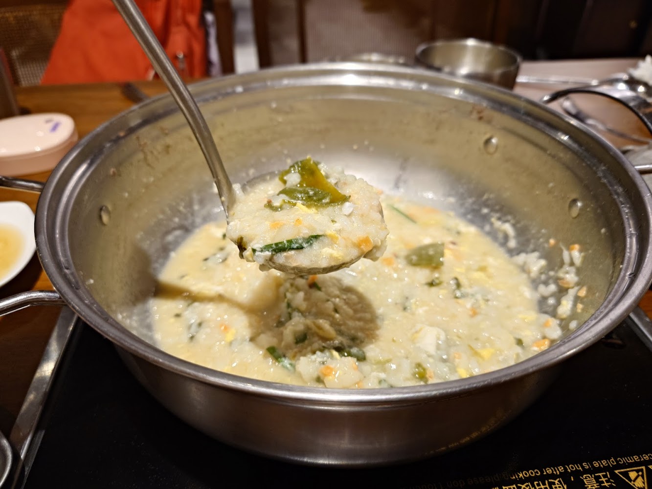 冒著熱氣的濃稠雜菜粥，米飯與青菜融合在一起