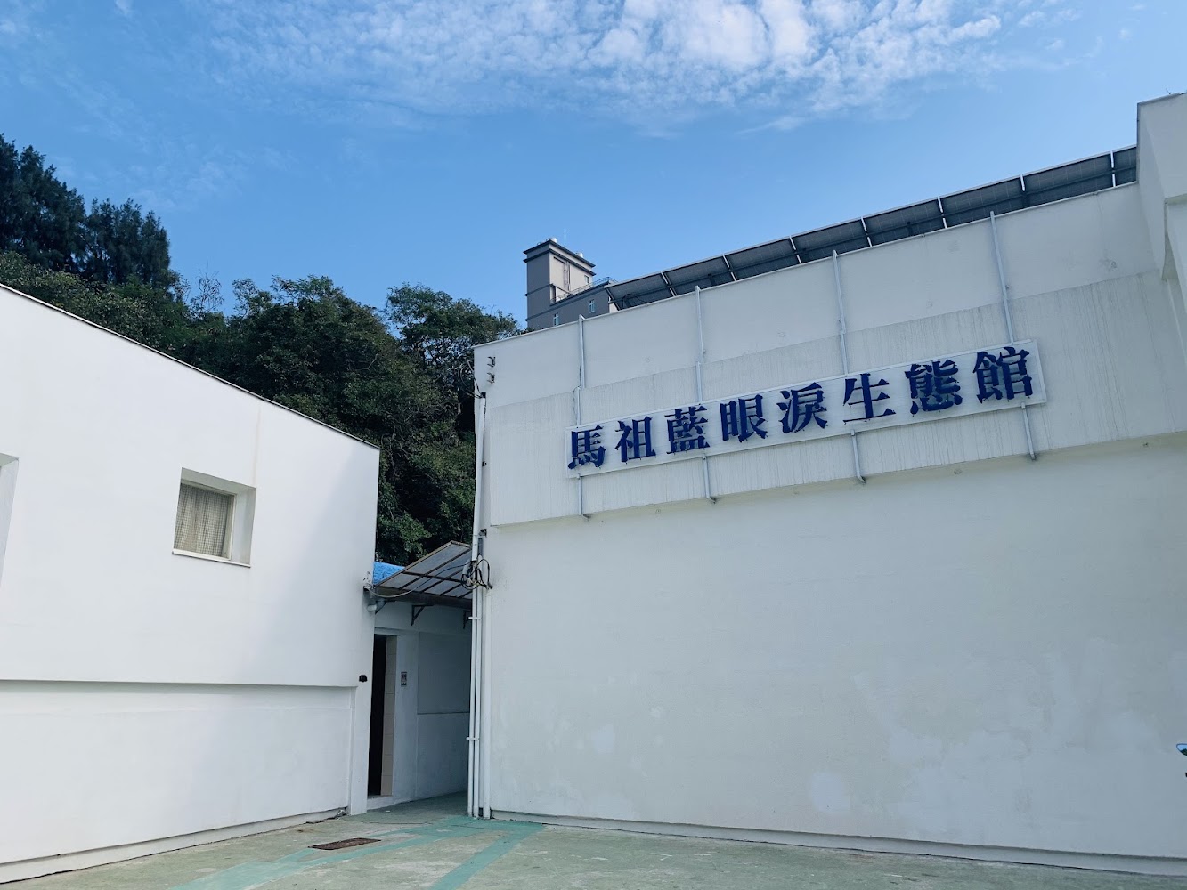 馬祖藍眼淚生態館白色外觀與館名招牌