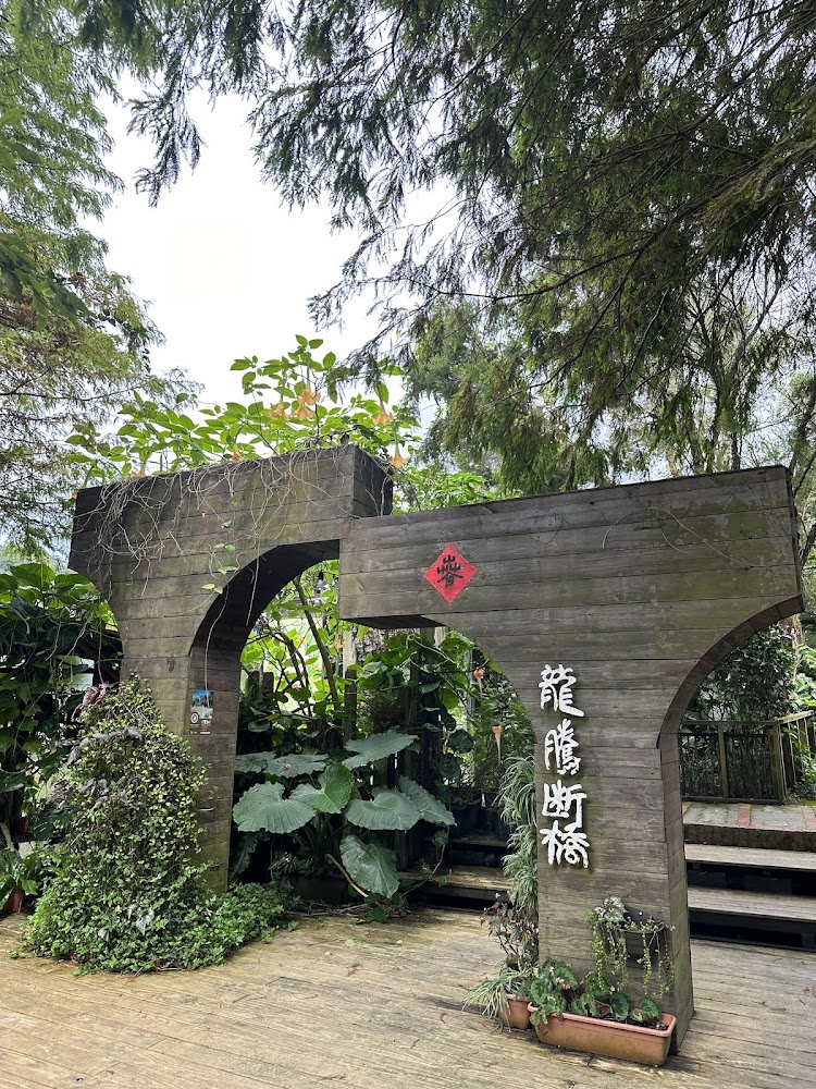 木製拱門與龍隱斷橋字樣，周圍綠意豐富