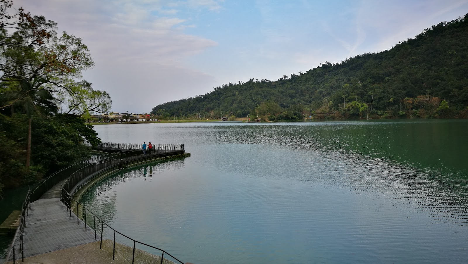 宜蘭梅花湖全景，弧形橋連結湖心島，湖面倒映藍天白雲