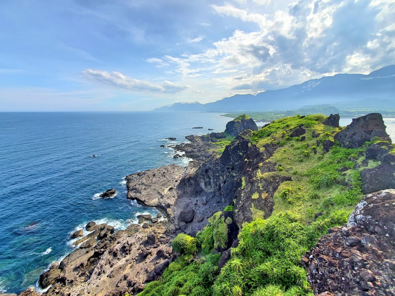 壯闊海岸線與藍海綠岩山景