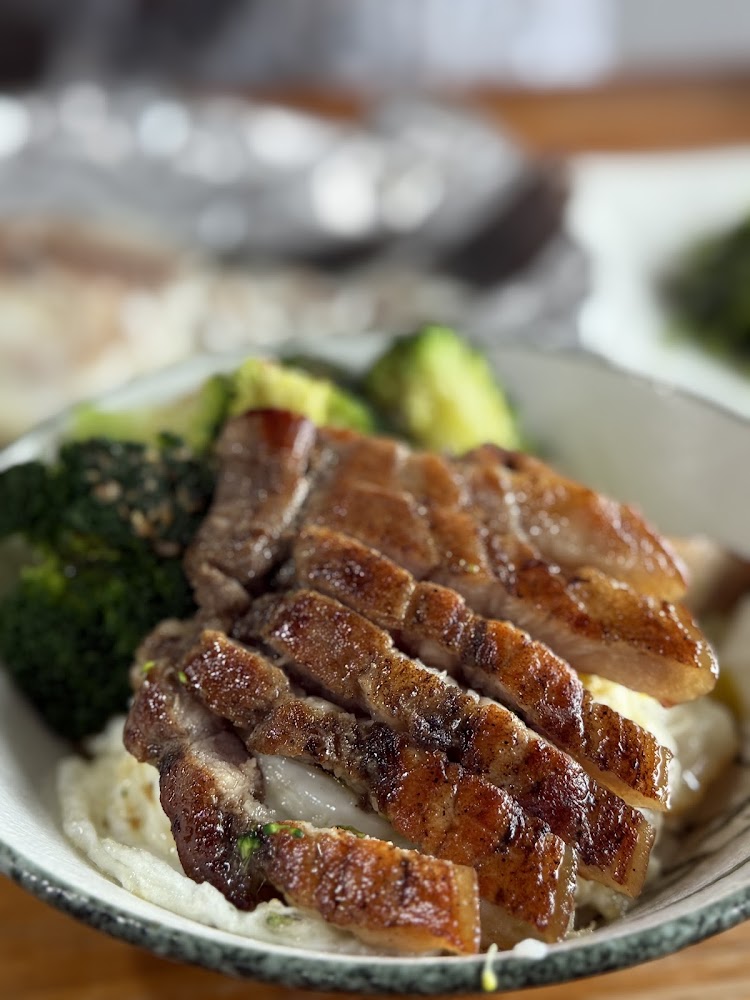 碗內有切片酥脆燒肉、花椰菜與蛋的特寫