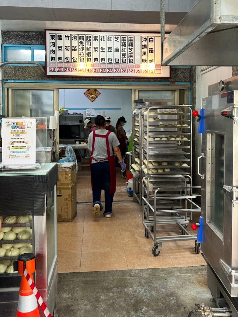 纏記東河包子座位區，桌上擺著品牌飲料杯與包子紙袋