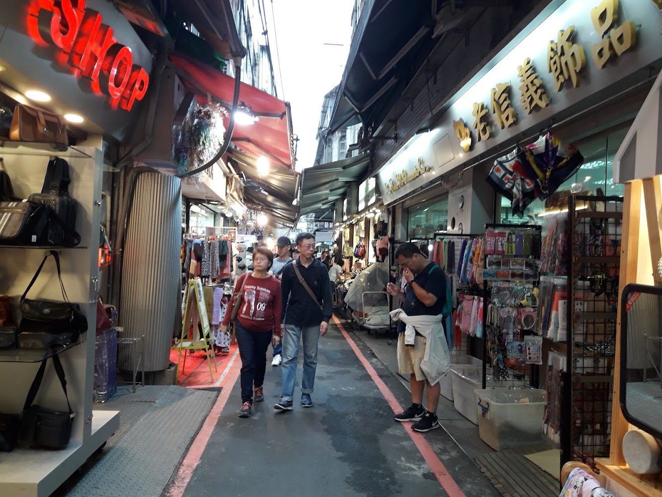 華陰街商圈步行街景，兩旁販售包包、飾品與生活用品。