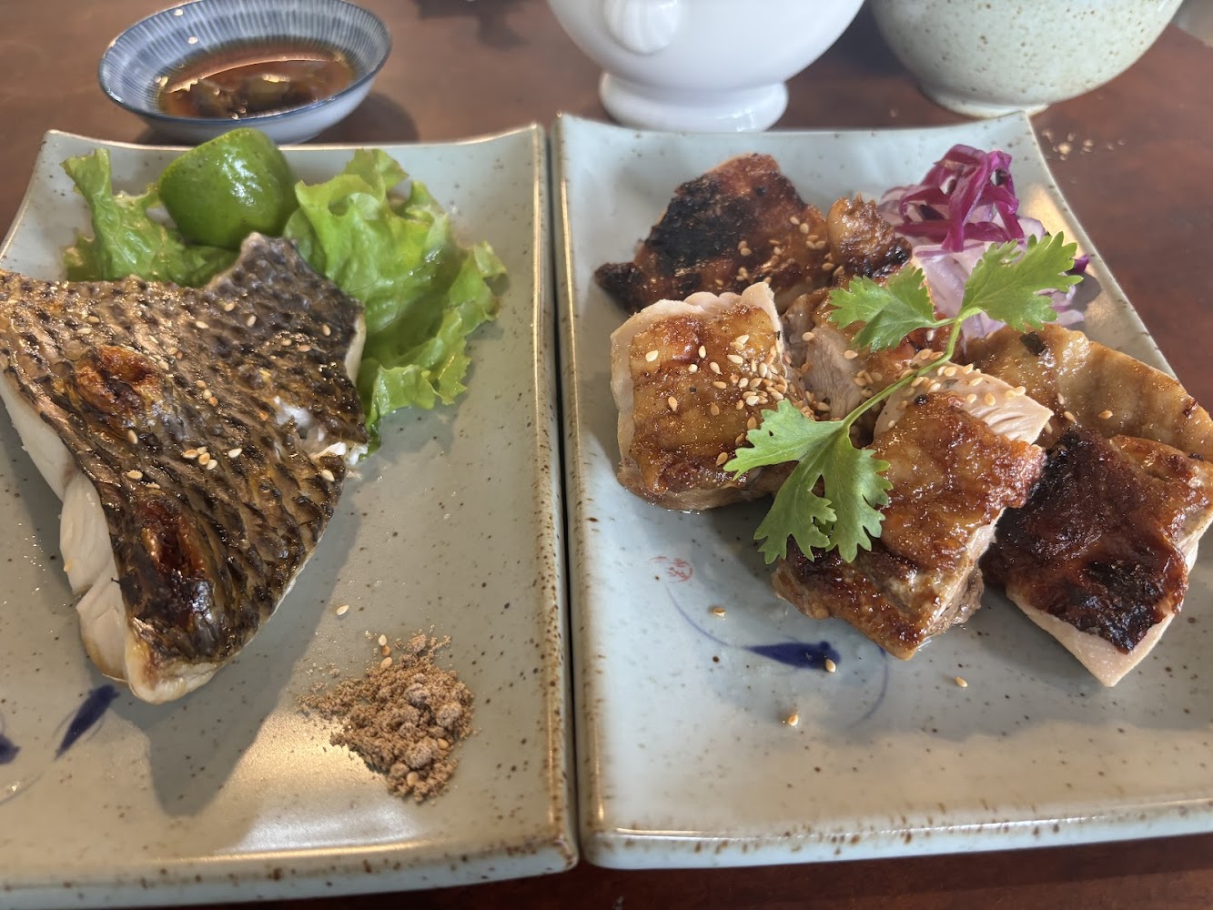 兩道烤魚與烤雞料理並列的精緻餐盤