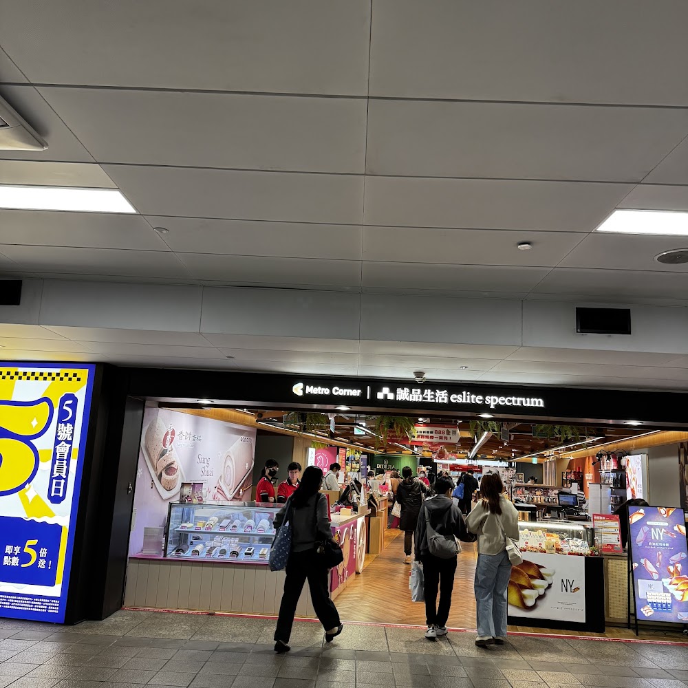 誠品生活站前店商場入口，人潮進出與亮眼廣告